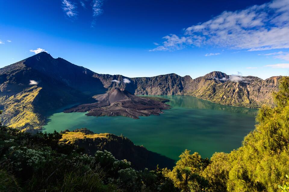 Paisaje volcánico con un lago y montañas circundantes.
