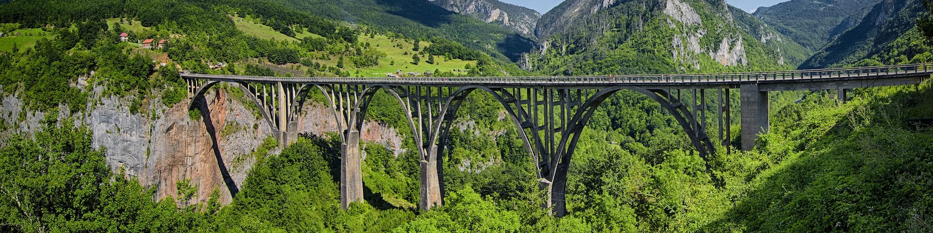 A bridge over a gorge with mountains in the background.
