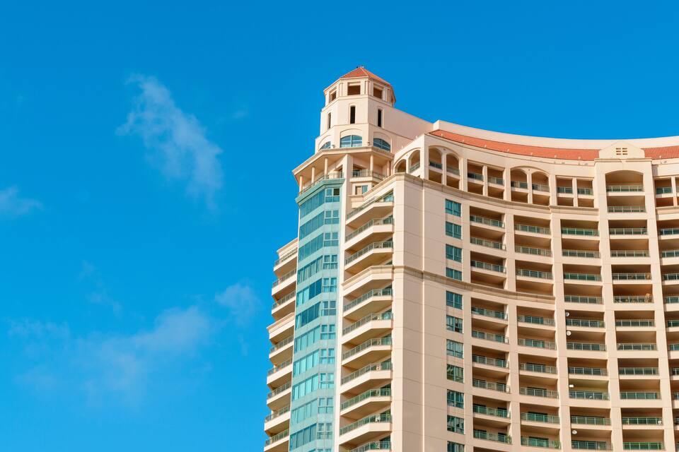 Un hotel alto con múltiples balcones y una torre distintiva.