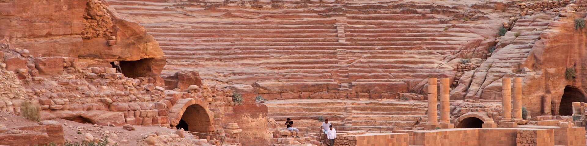 Teatro de los Nabateos que incluye elementos patrimoniales y ruinas de un edificio y también un pequeño grupo de personas