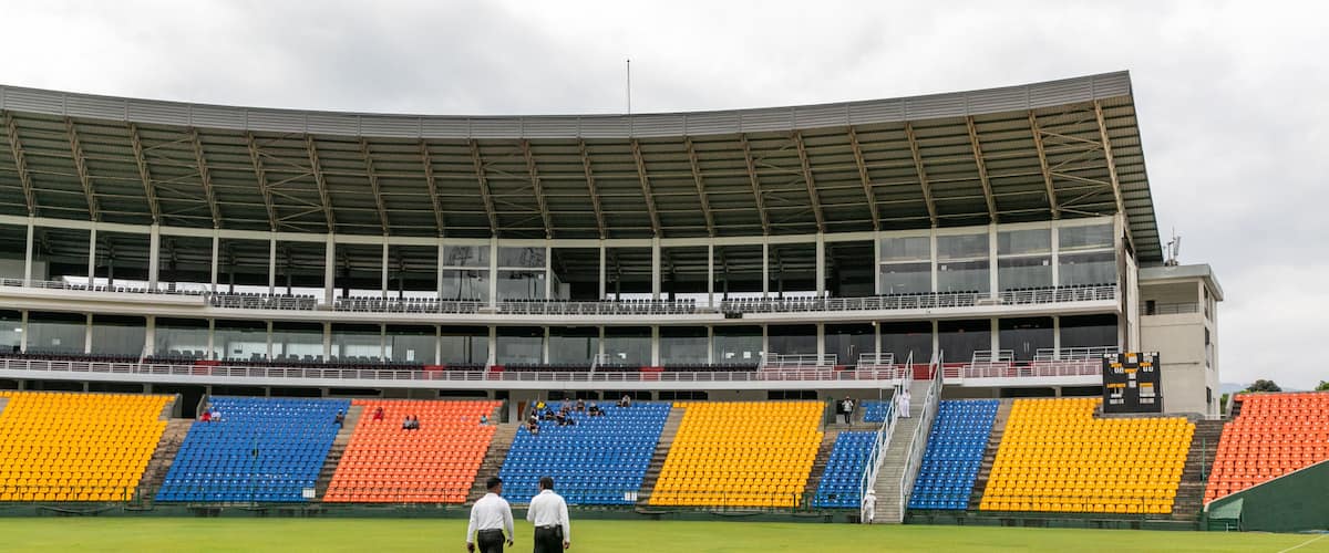 A stadium with tiered seating and a green field.