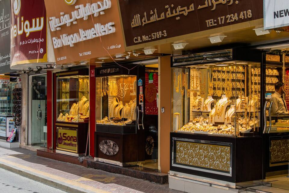 A jewelry store with glass display cases filled with gold jewelry.