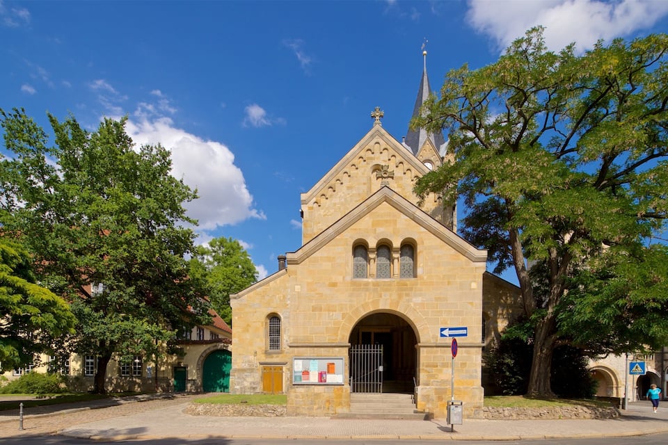 Une église historique en pierre, dotée d’un toit en forme de flèche et d’un clocher élancé.