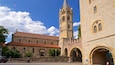 A historic building with a tall tower and arched windows.