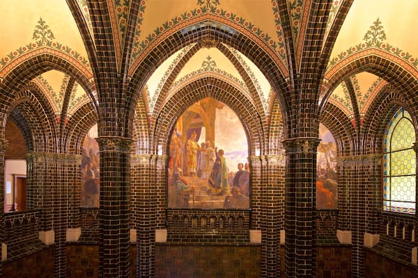 A cathedral interior with Gothic arches and stained glass windows.