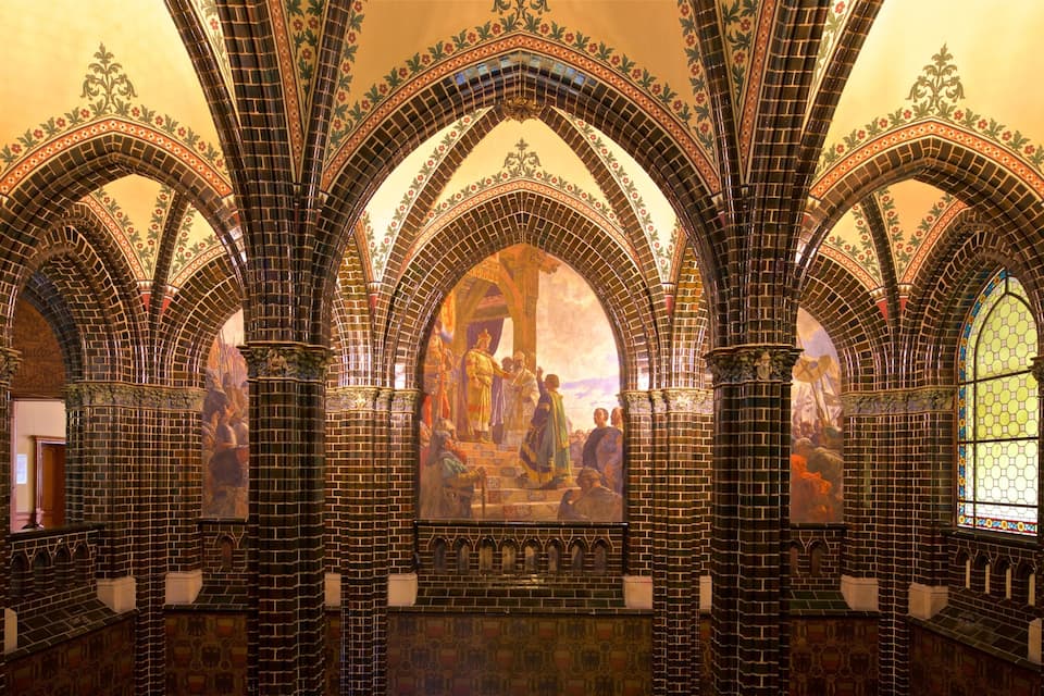 A cathedral interior with Gothic arches and stained glass windows.