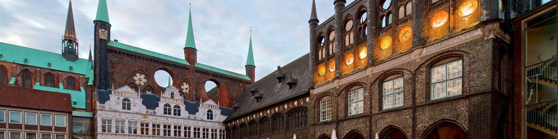 A historic building with multiple spires and a courtyard with outdoor seating.