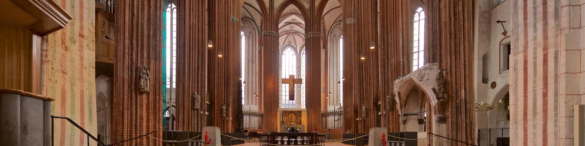 A cathedral interior with tall, arched windows and a central altar.