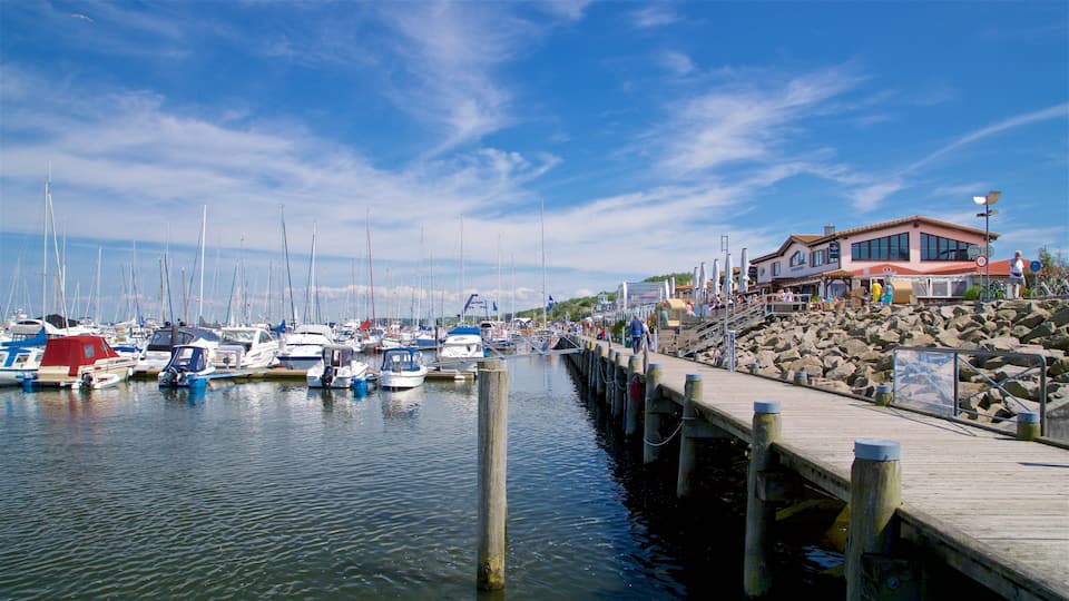 A marina with boats docked, a wooden pier, and a building with outdoor seating.