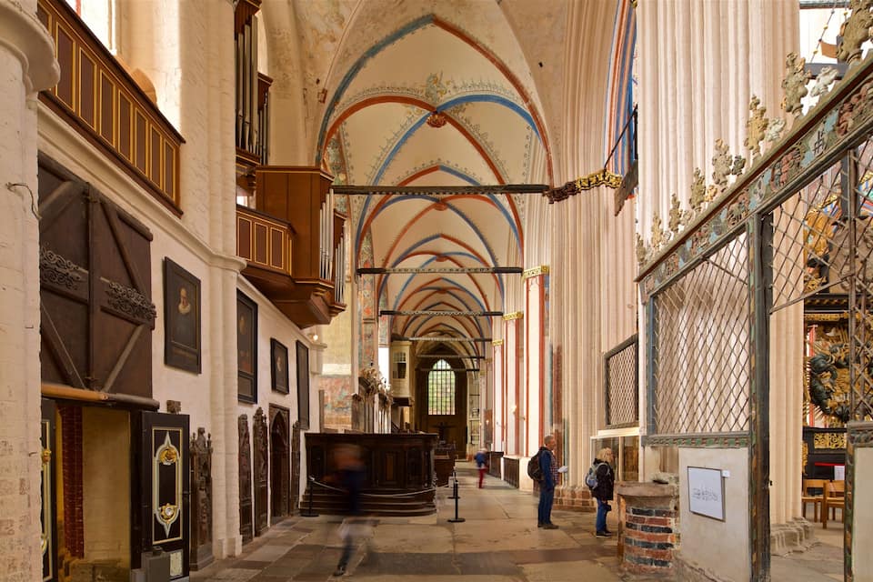 An ornate church interior with high ceilings, arched windows, and detailed woodwork.