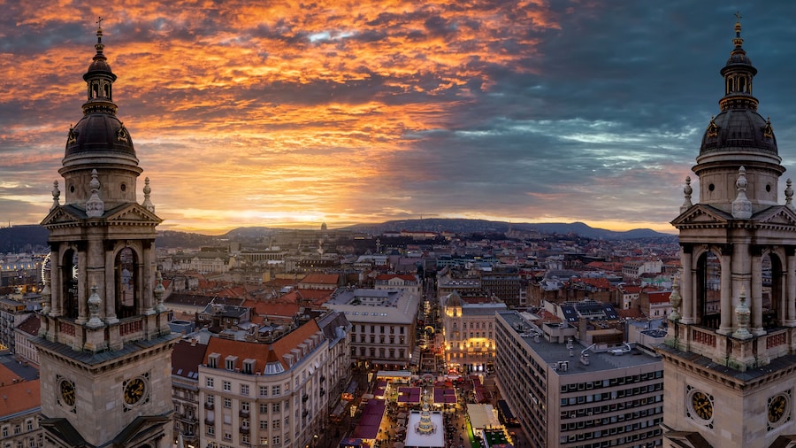 Panoramic view from the Saint Stephand Basilica to the skyline of Budapest, Hungary, with a christmas market at the square during a colorful winter sunset