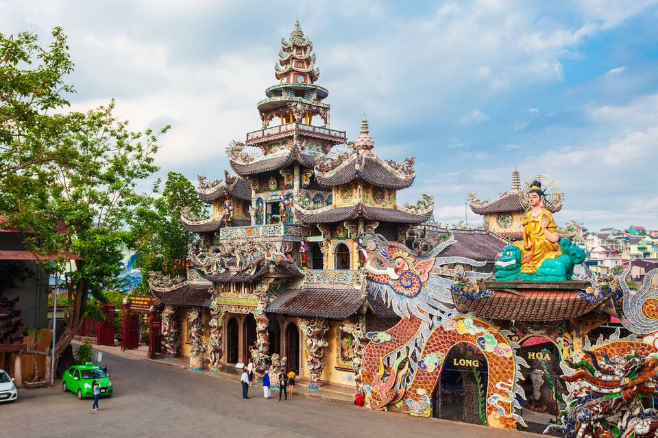 Ein farbenfroher Tempel mit filigraner Architektur und einer Drachenstatue.