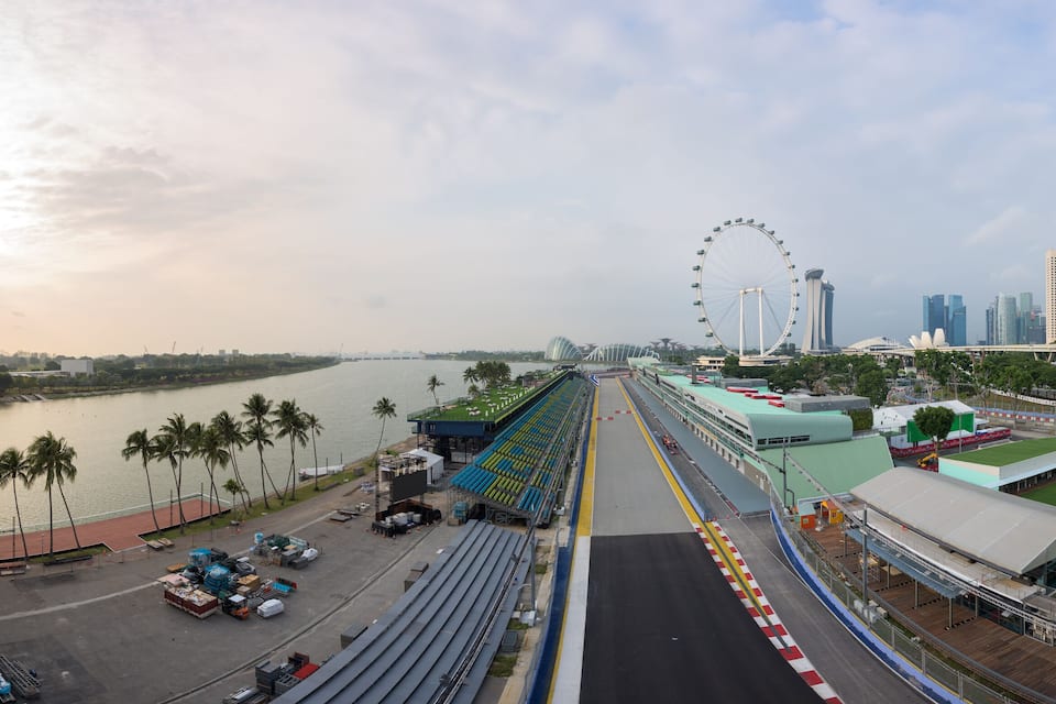 Uma ponte com uma roda gigante e edifícios modernos ao fundo.