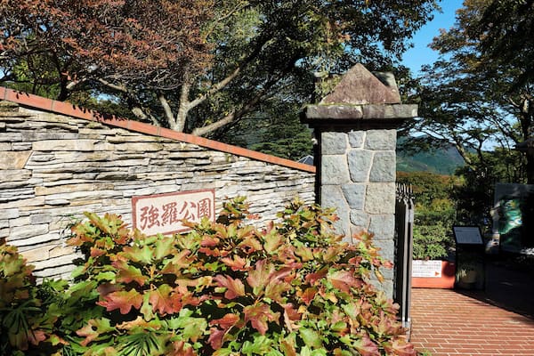 A stone wall with a sign, a stone pillar, and a pathway.