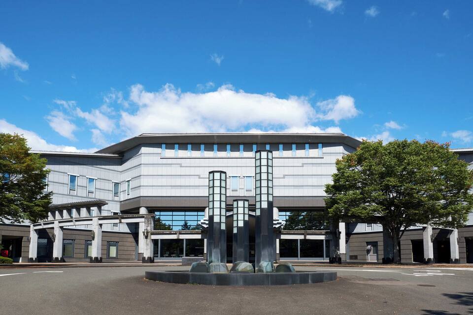 Un bâtiment moderne doté d’une façade originale et d’une sculpture centrale.