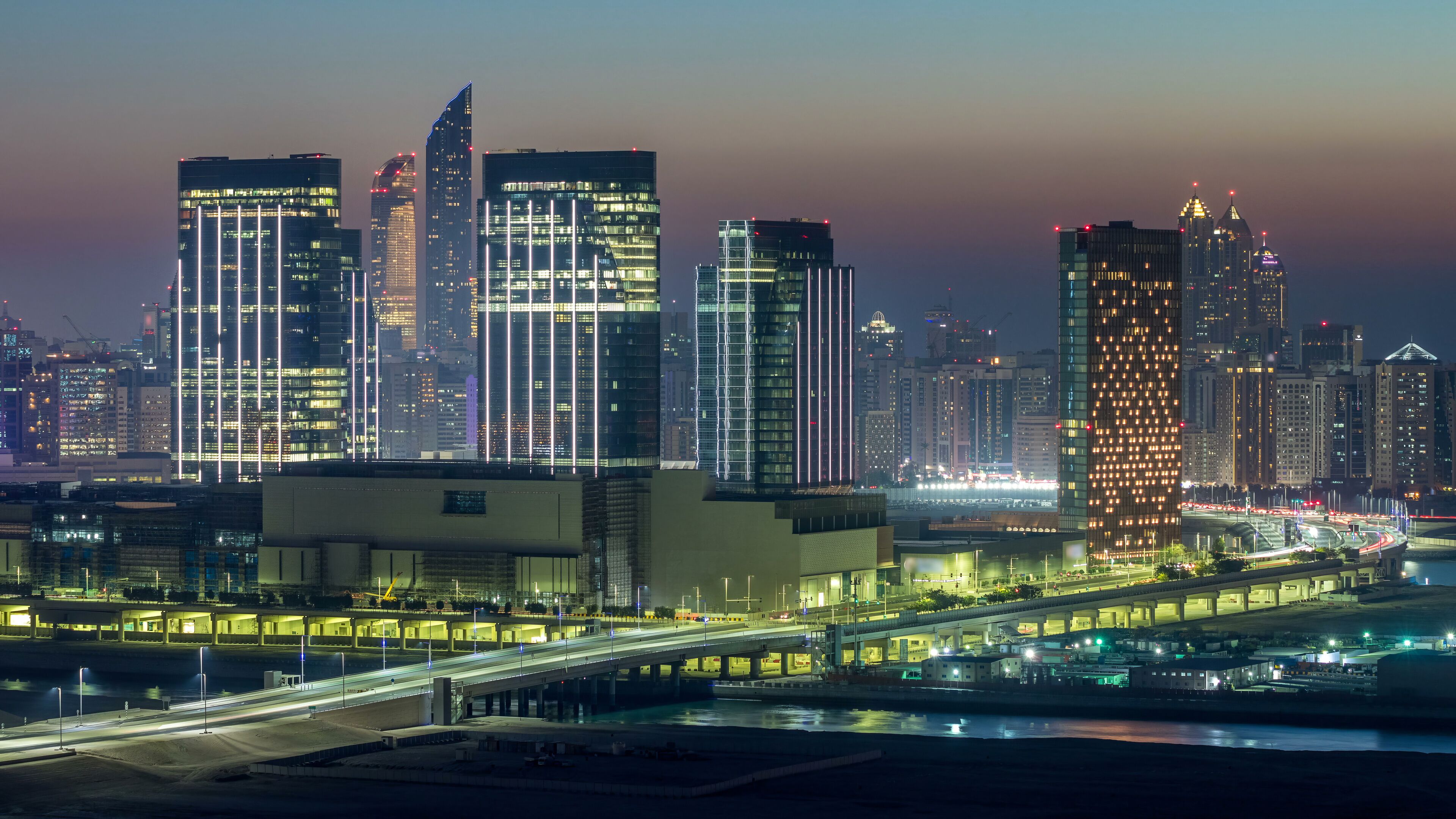 Buildings on Al Reem island in Abu Dhabi day to night timelapse from above.