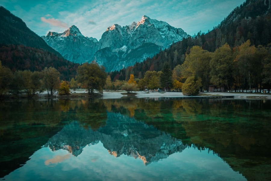 Beautiful lake jasna in kranjska gora with visible reflections of Razor and Skrlatica in the water in early autumn