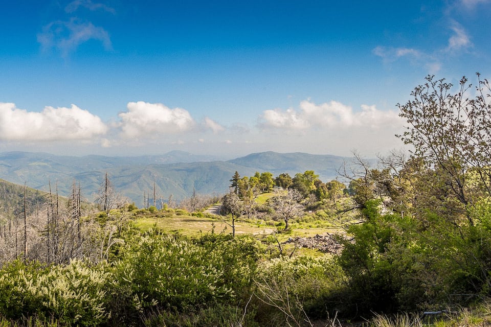 A mountainous landscape with green vegetation and a clear blue sky.