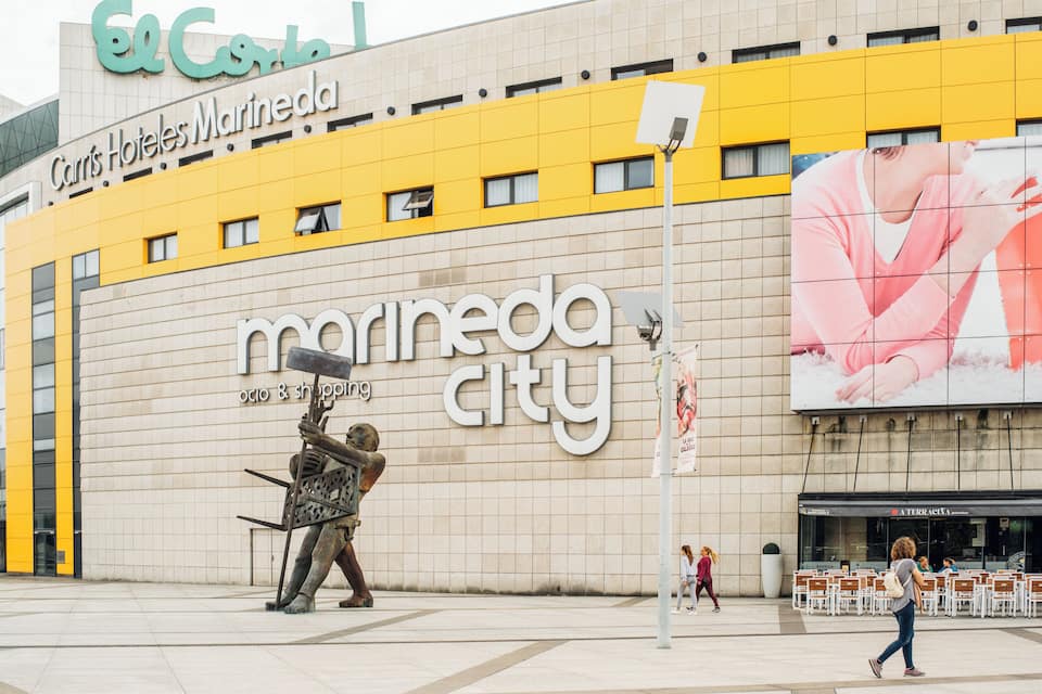Un edificio grande con fachada amarilla y un letrero que dice "Carrís Hotels Maríndia City".
