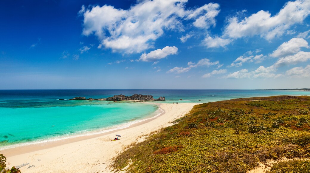 Dragon Cay at low tide, causeway mostly uncovered, and the curving white sand beach viewed from the cliffs above. Mudjin Harbor, Middle Caicos