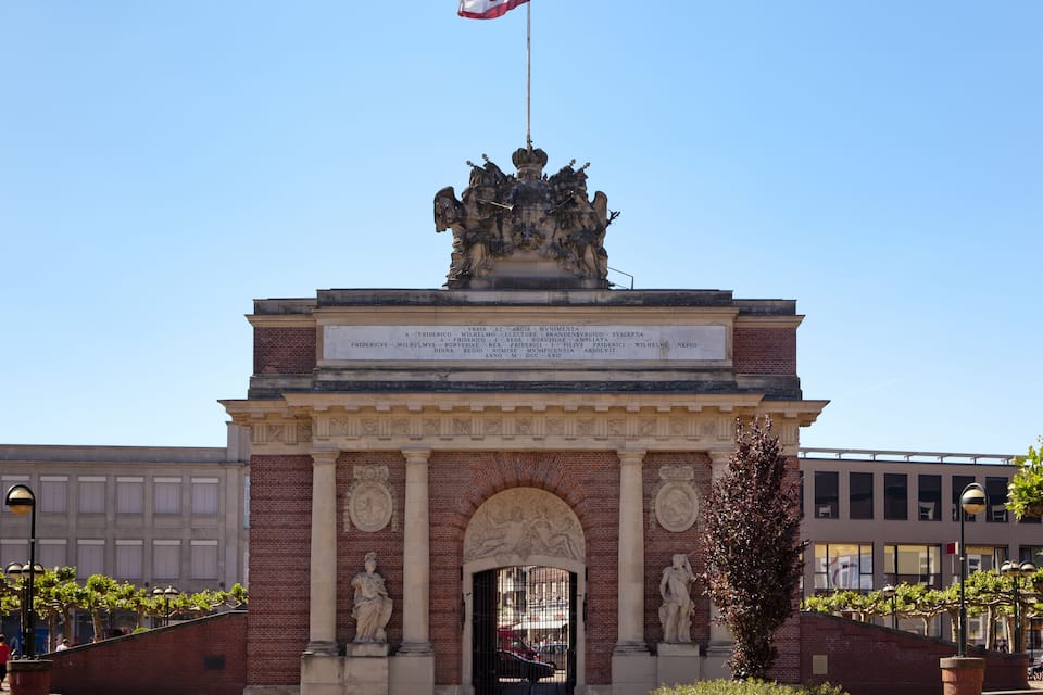 A historical monument with inscriptions, statues, and a flag.