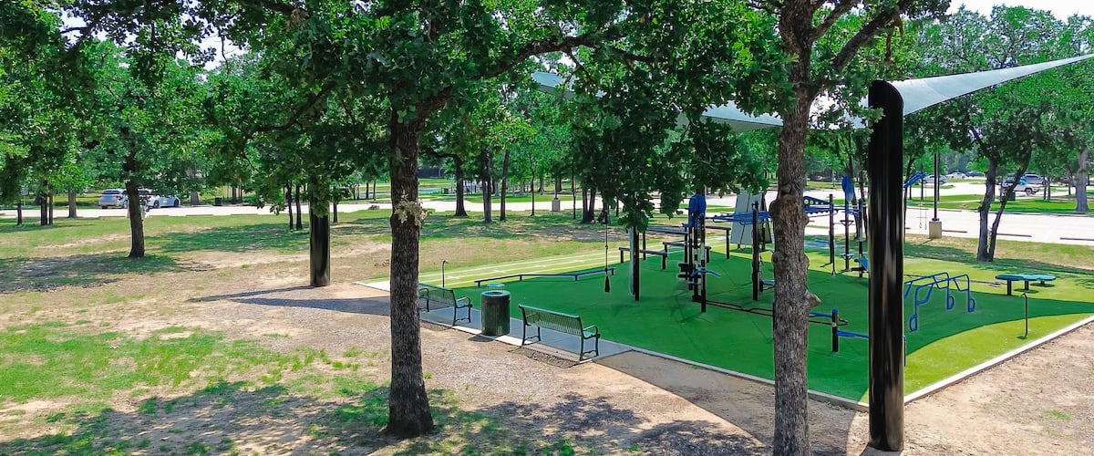 Panorama aerial view outdoor fitness equipment on artificial grass turf, shade sail cover, public community recreation center in Flower Mound, Texas, single double stations, complete gyms courses