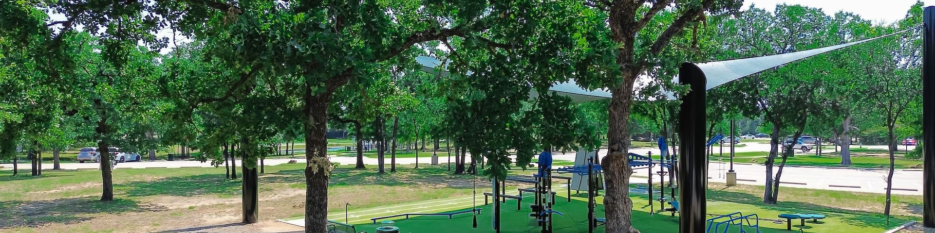Panorama aerial view outdoor fitness equipment on artificial grass turf, shade sail cover, public community recreation center in Flower Mound, Texas, single double stations, complete gyms courses