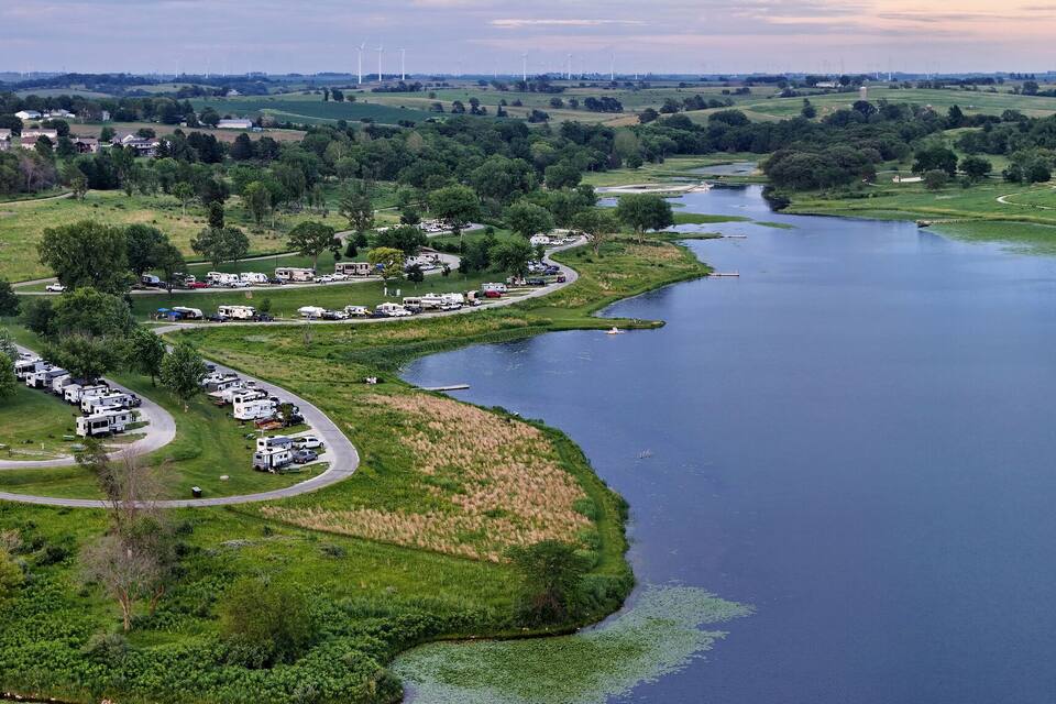 A river winding through a green landscape with a campground on one side.