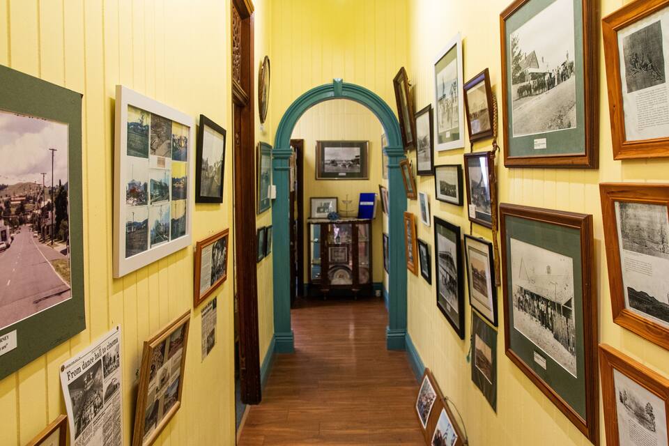 A hallway with historical photographs and a wooden archway.