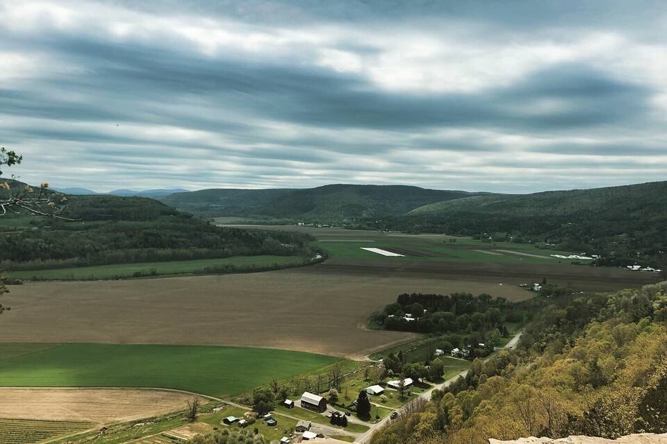 A rural landscape with rolling hills, fields, and a small village.