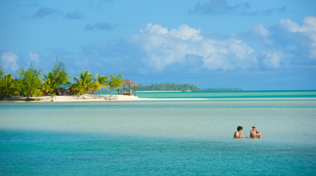 Aitutaki featuring general coastal views as well as a small group of people