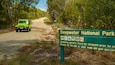 Un panneau vert indiquant le parc national de Deepwater et fournissant des informations sur les permis de camping.