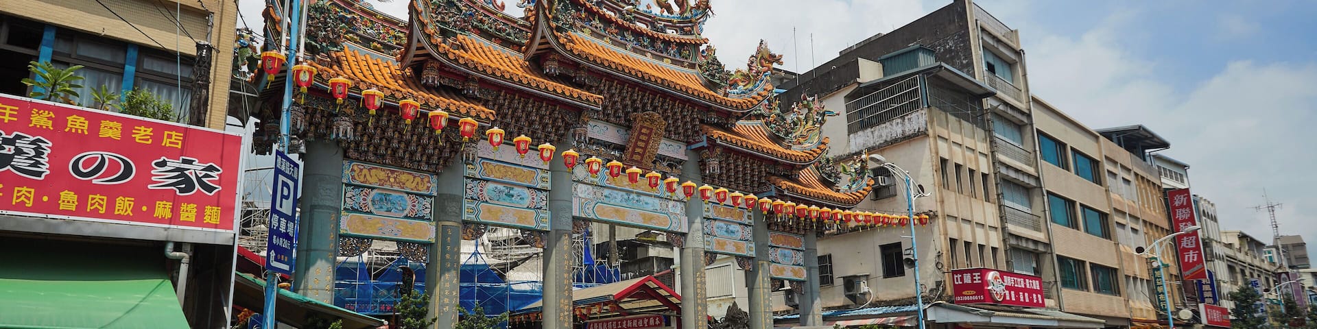 Una calle con arquitectura china tradicional, incluyendo techos ornamentados y faroles de colores.