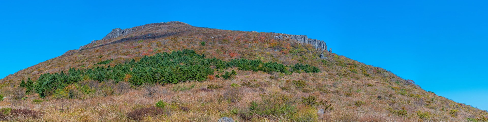 Una montaña con un cielo azul despejado.