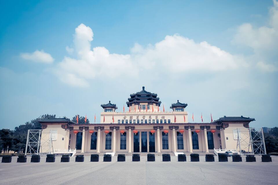 A traditional building with a multi-tiered roof, large windows, and red lanterns.