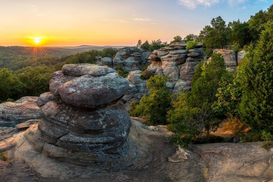 A rocky landscape with a sunset in the background.