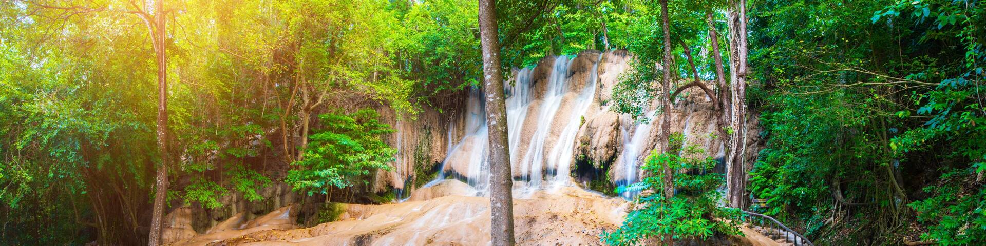 A waterfall cascading into a turquoise pool surrounded by lush greenery.