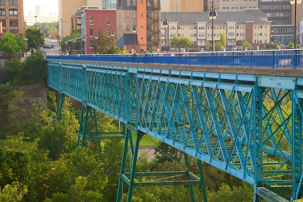 Un pont en acier bleu, avec une vue sur la ville en arrière-plan.