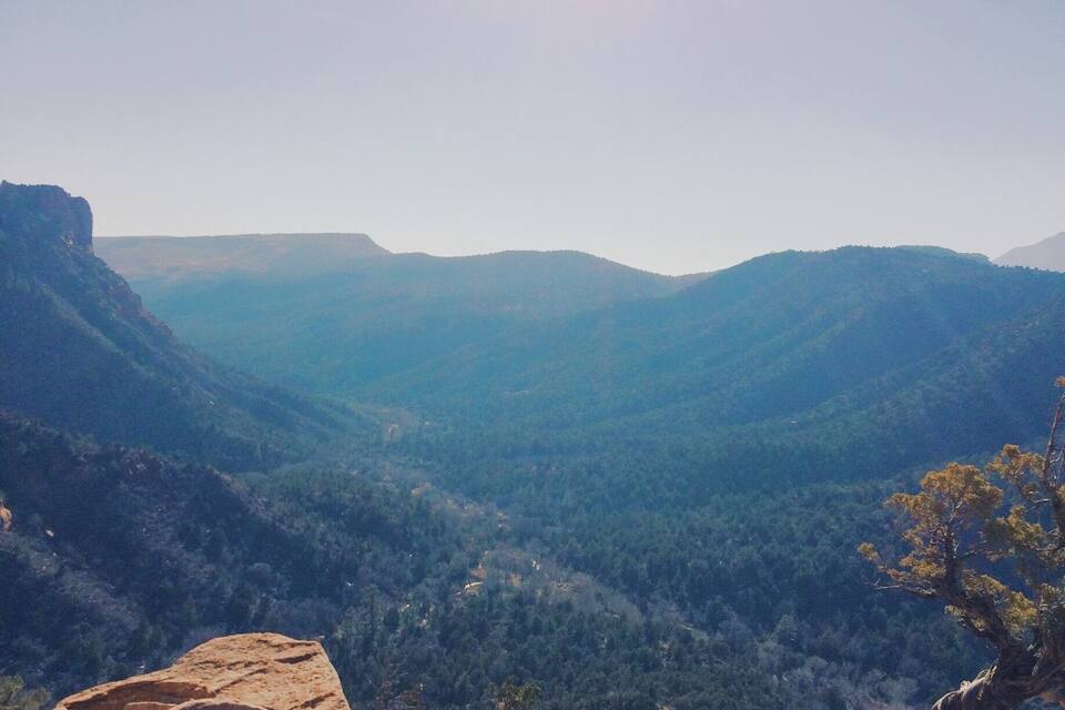 A mountainous landscape with a clear sky and a prominent rock formation in the foreground.