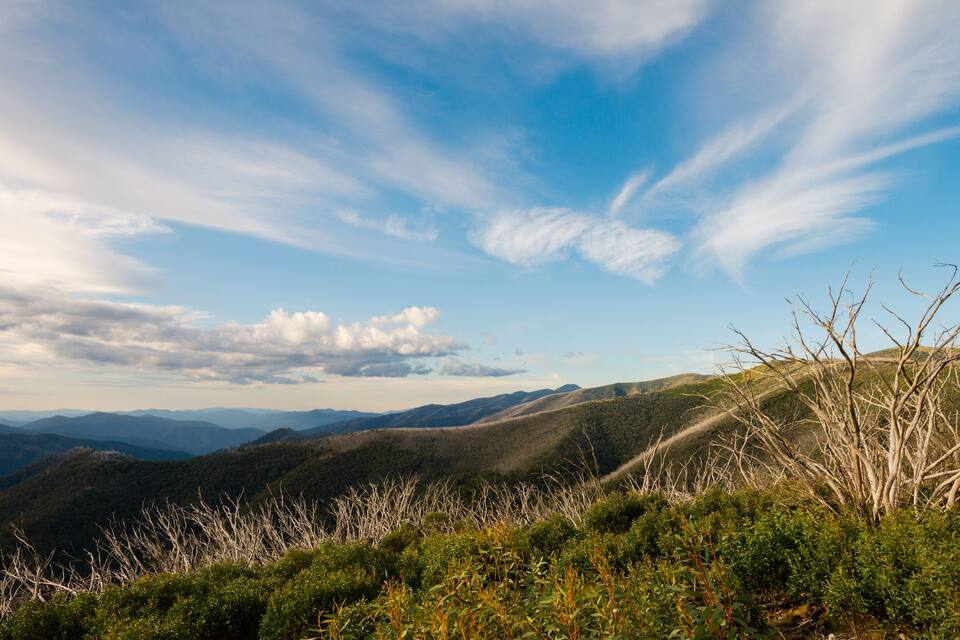 A mountainous landscape with a clear sky and scattered clouds.
