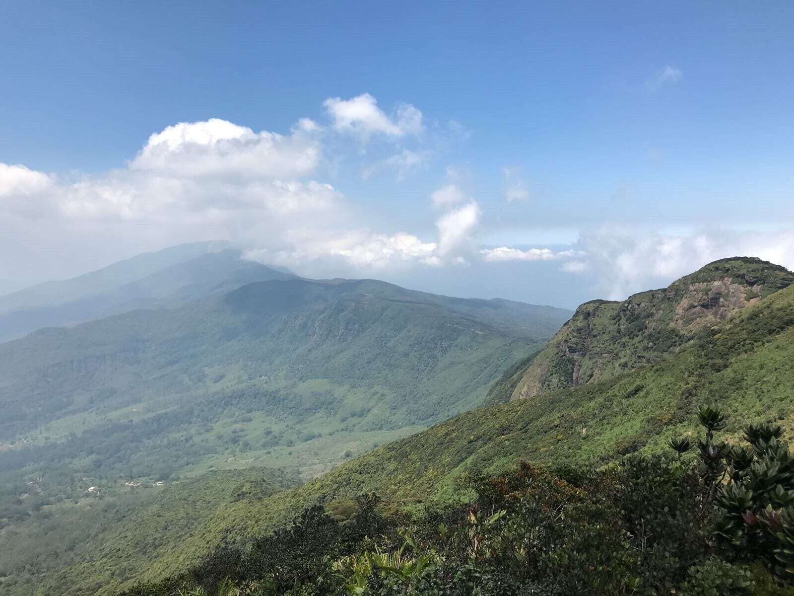 A mountainous landscape with lush green vegetation and a clear blue sky.