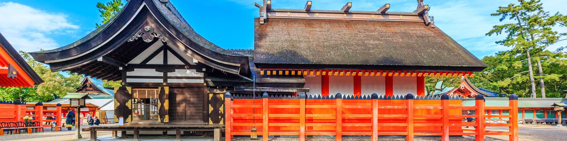 A traditional Japanese temple with a curved roof and a red gate.