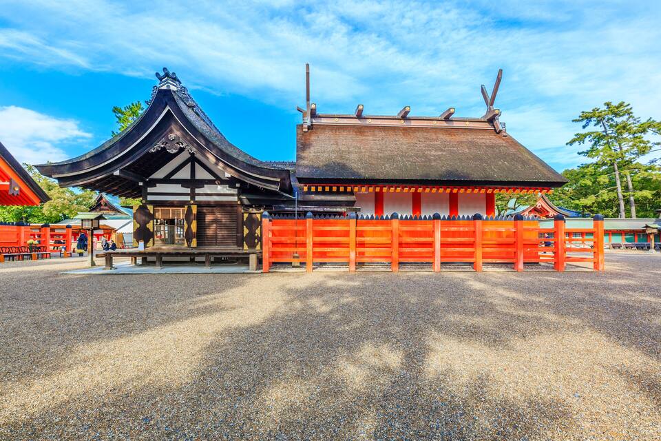 A traditional Japanese temple with a curved roof and a red gate.