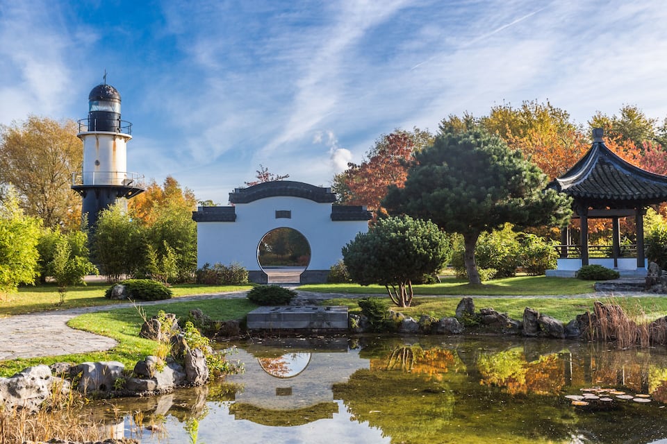 Un jardí japonès tradicional amb un fanal, una pagoda i un estany.