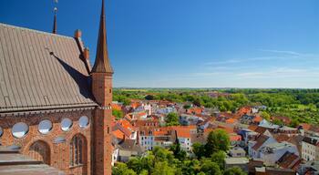 A church with a tall spire and a brick facade with circular windows.