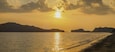 view panorama seaside evening on long beach of limestone mountain in the sea with yellow sun light and cloudy sky background, sunset at Pak Bara Beach, La-ngu District, Satun, southern Thailand.