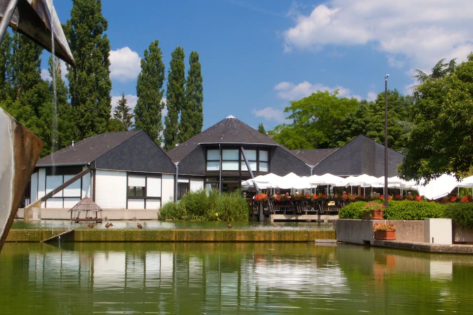 Ein Restaurant am Seeufer mit Außenbereich und Teich.