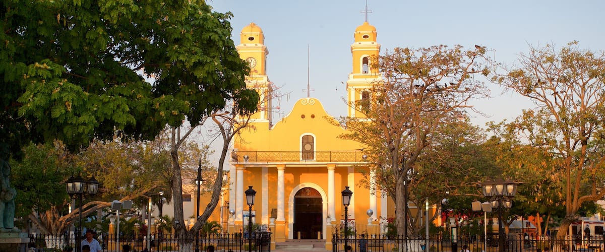Iglesia de Nuestra Señora del Carmen que incluye una iglesia o catedral, un jardín y un atardecer