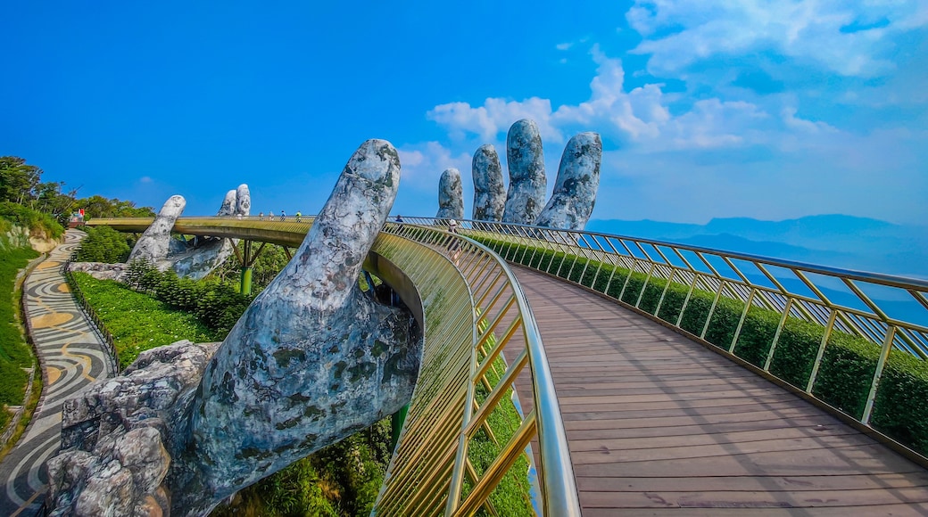 Empty Golden Bridge in Ba Na hills, Da Nang, Vietnam on a sunny day. Lifted by two giant concrete hands. Iconic world famous bridge in the mountains