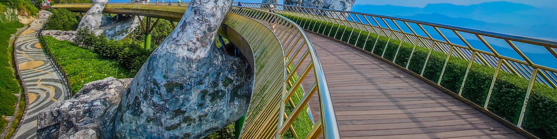 Empty Golden Bridge in Ba Na hills, Da Nang, Vietnam on a sunny day. Lifted by two giant concrete hands. Iconic world famous bridge in the mountains